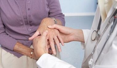 mjeku ekzaminon nyjet e duarve me artrozë dhe artrit